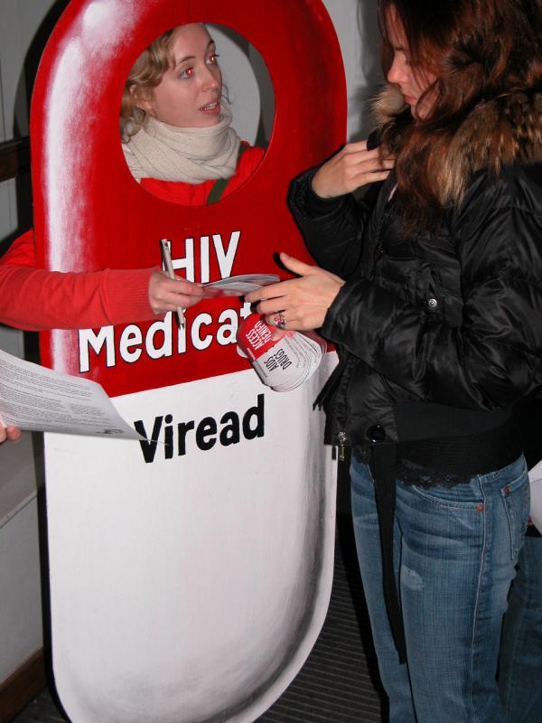 Photo of LSE P&Per in pill costume handing collecting signatures for Treat AIDS Now action-cards