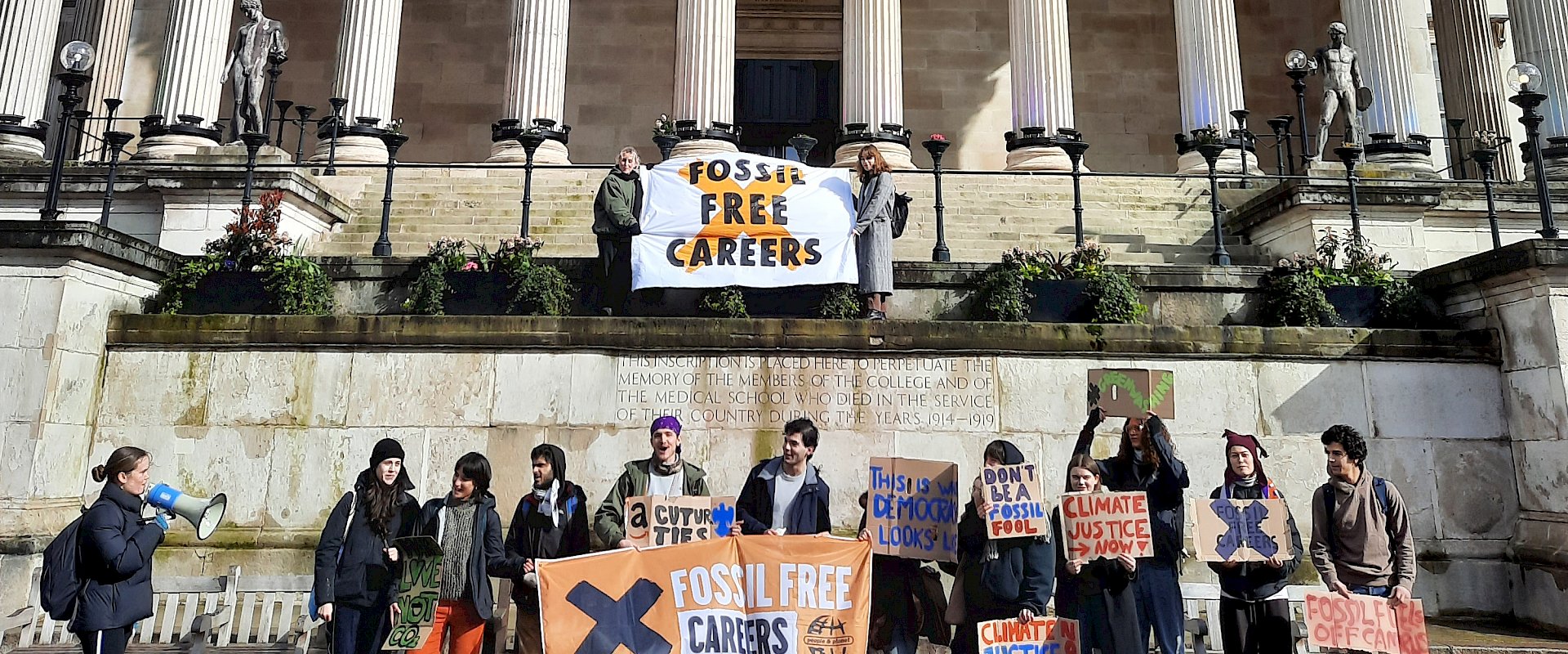 Students stand with Fossil Free Careers banner and placards outside UCL university building