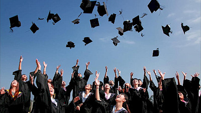 Image of students throwing hats in the air