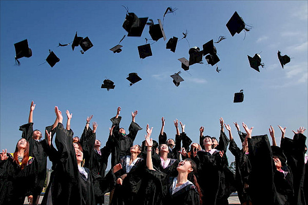 Image of students throwing hats in the air