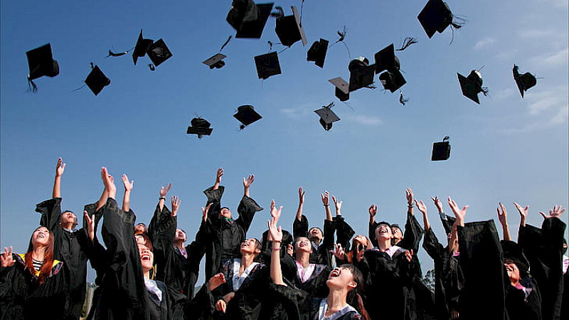 Image of students throwing hats in the air