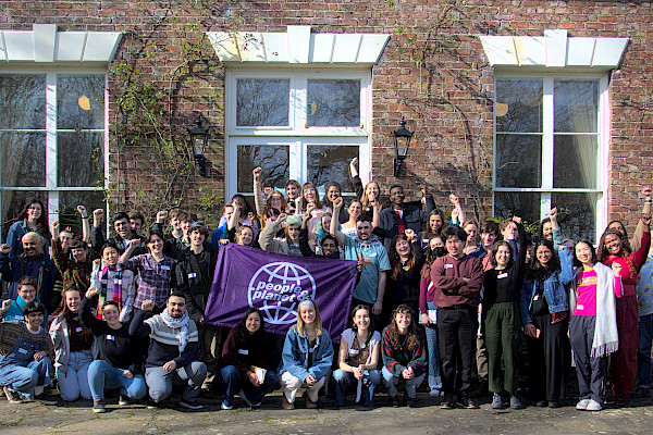 Large group of students with fists raised and People & Planet banner
